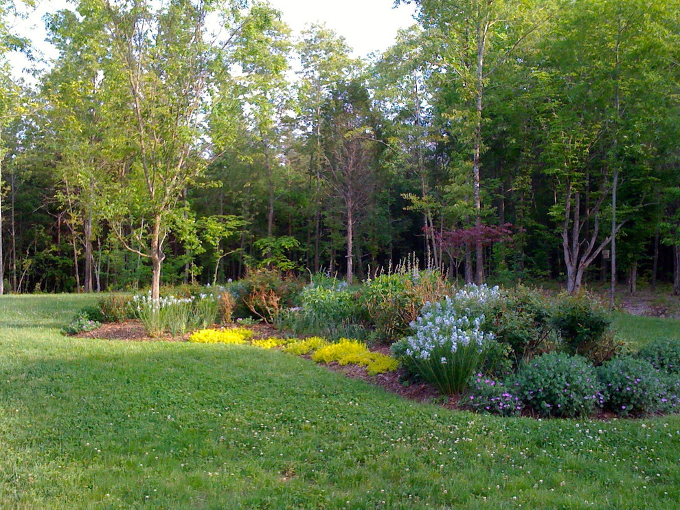 Foto di un grande orto in giardino chic esposto a mezz'ombra dietro casa in primavera con pacciame