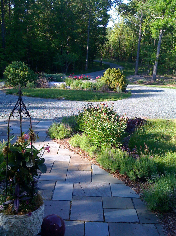 This is an example of a huge traditional partial sun front yard stone driveway in Richmond for spring.