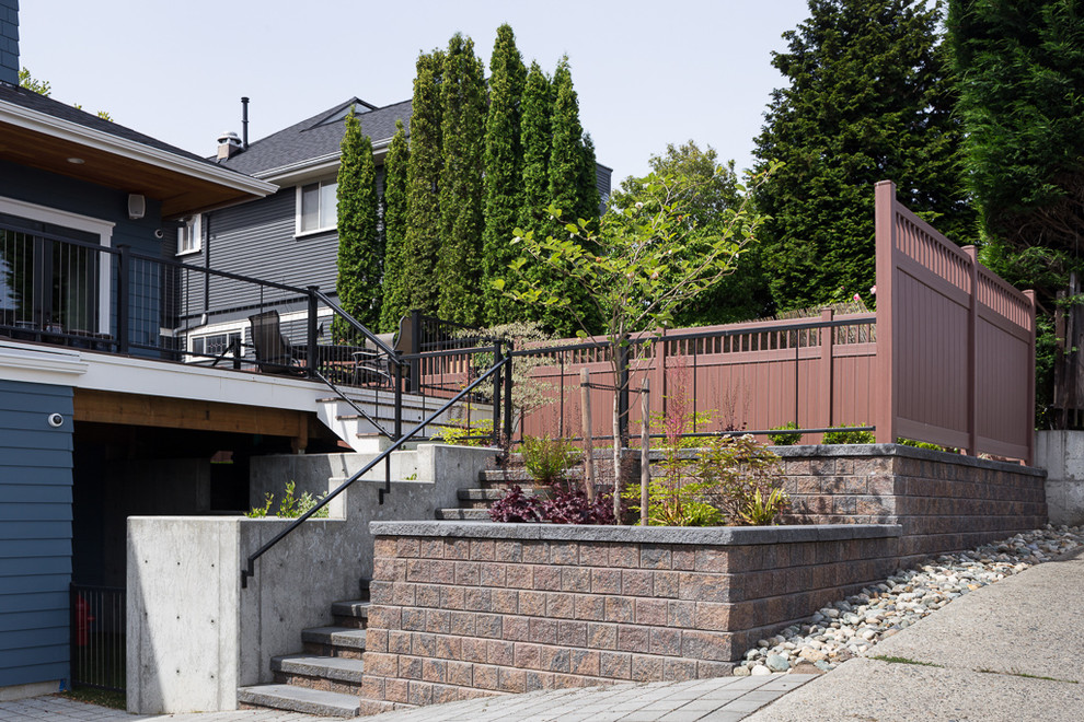 Immagine di un giardino formale stile americano esposto a mezz'ombra di medie dimensioni e davanti casa in estate con un muro di contenimento e pavimentazioni in mattoni