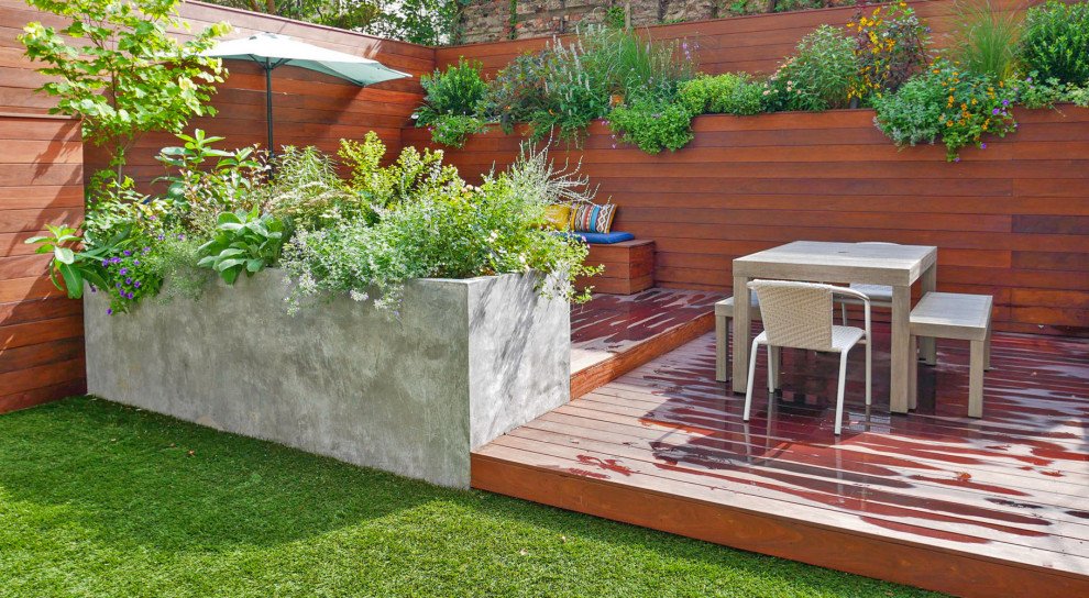 Стильный дизайн: маленький солнечный участок и сад на заднем дворе в современном стиле с перегородкой для приватности, хорошей освещенностью и настилом для на участке и в саду - последний тренд