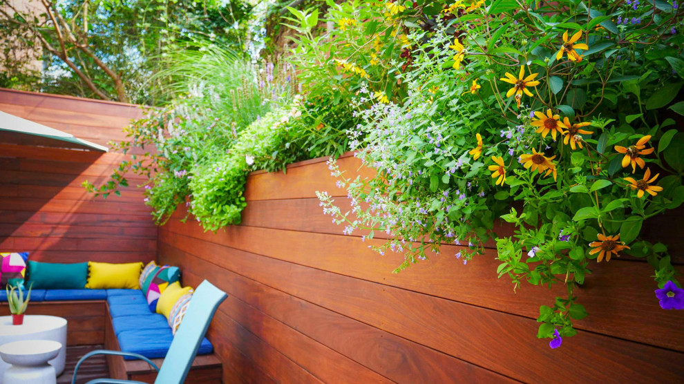 Design ideas for a small contemporary privacy and full sun backyard landscaping in New York with decking.