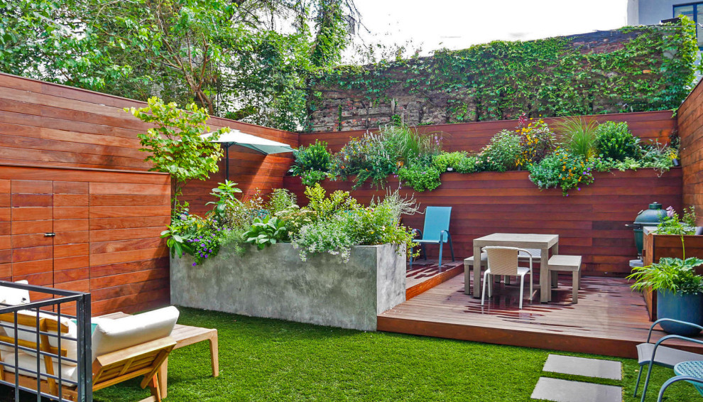 Идея дизайна: маленький солнечный участок и сад на заднем дворе в современном стиле с перегородкой для приватности, хорошей освещенностью и настилом для на участке и в саду