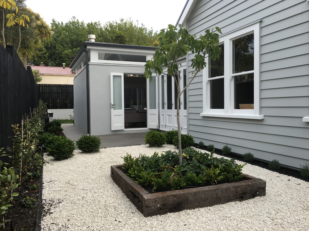 Kleiner Rustikaler Kiesgarten neben dem Haus mit Kübelpflanzen in Auckland