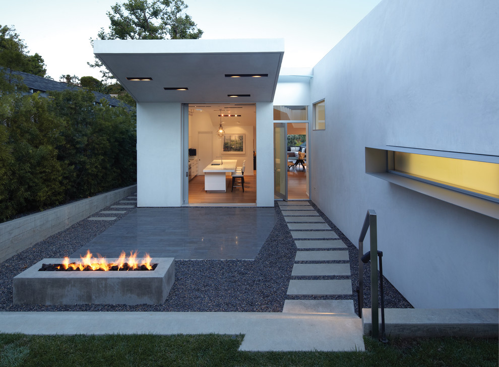 Medium sized modern front partial sun garden in Los Angeles with a fire feature and concrete paving.