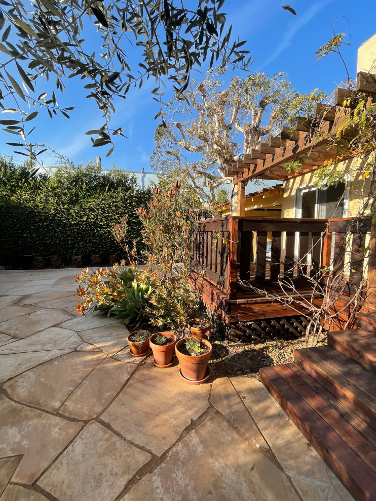 Foto di un giardino xeriscape mediterraneo esposto in pieno sole di medie dimensioni e dietro casa in primavera con un focolare, pavimentazioni in mattoni e recinzione in legno