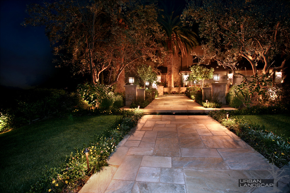 Design ideas for a large mediterranean front yard stone landscaping in Orange County.