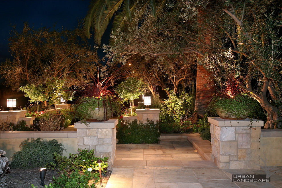 Idée de décoration pour un grand jardin avant méditerranéen avec des pavés en pierre naturelle.