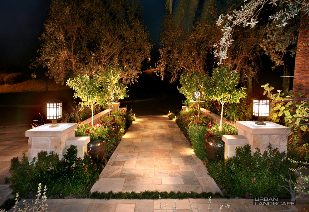 Großer Mediterraner Garten mit Auffahrt und Natursteinplatten in Orange County