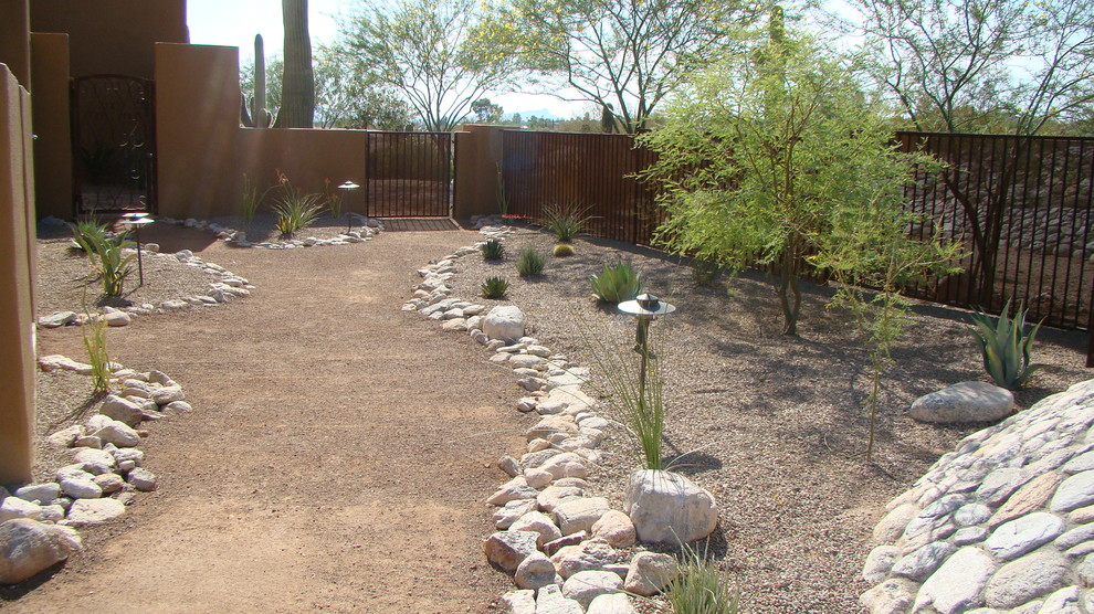 Ejemplo de jardín de secano de estilo americano de tamaño medio en patio trasero con gravilla