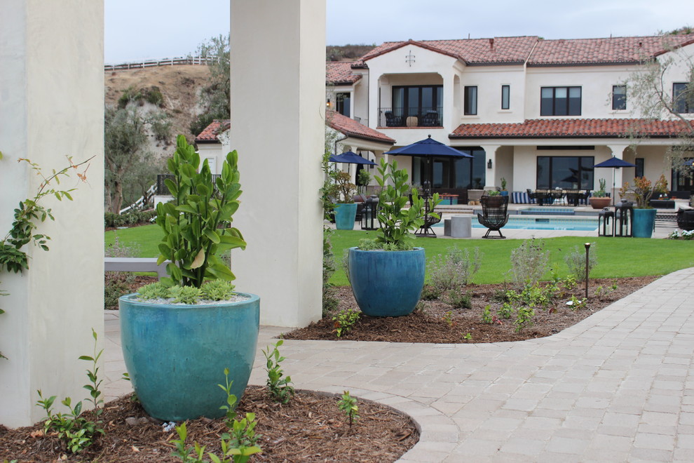 This is an example of a large traditional drought-tolerant and partial sun backyard concrete paver vegetable garden landscape in Orange County for summer.