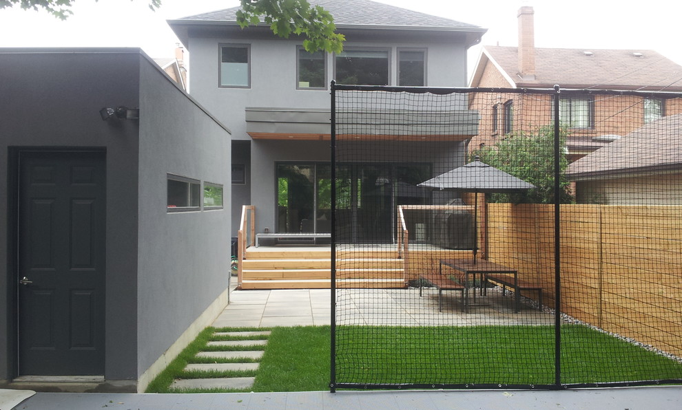 Kleiner, Schattiger Moderner Garten im Sommer, hinter dem Haus mit Sportplatz, Spielgerät und Betonboden in Toronto