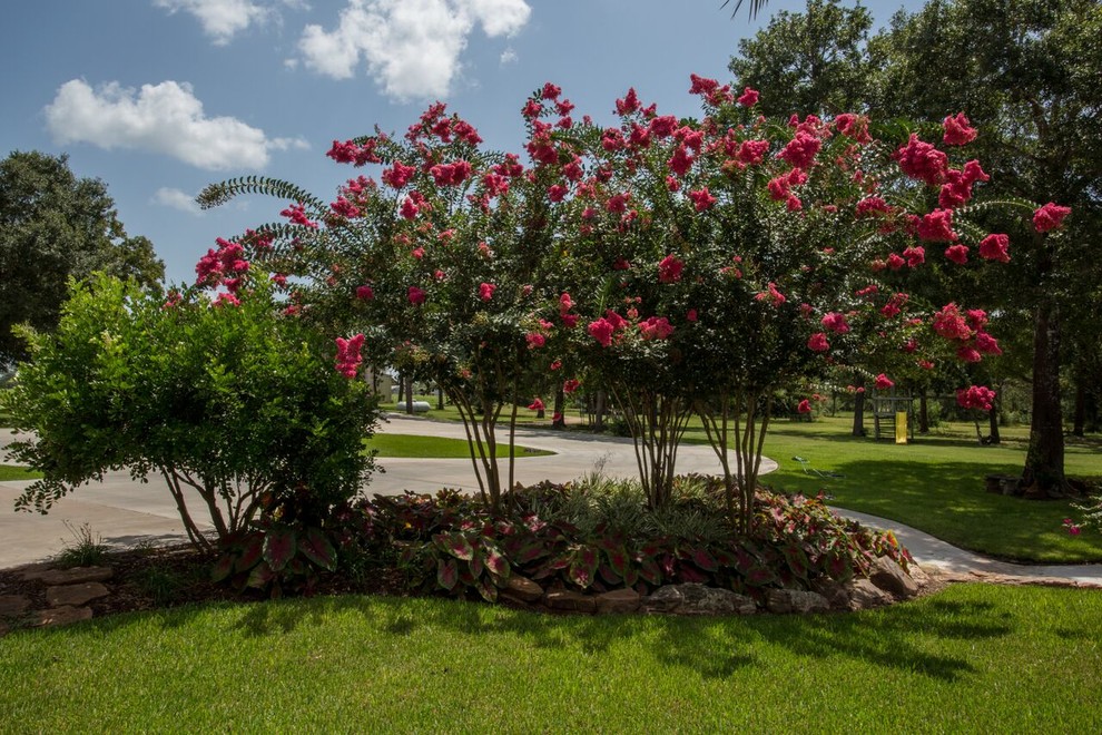 Großer, Schattiger Garten hinter dem Haus mit Kübelpflanzen und Natursteinplatten in Houston