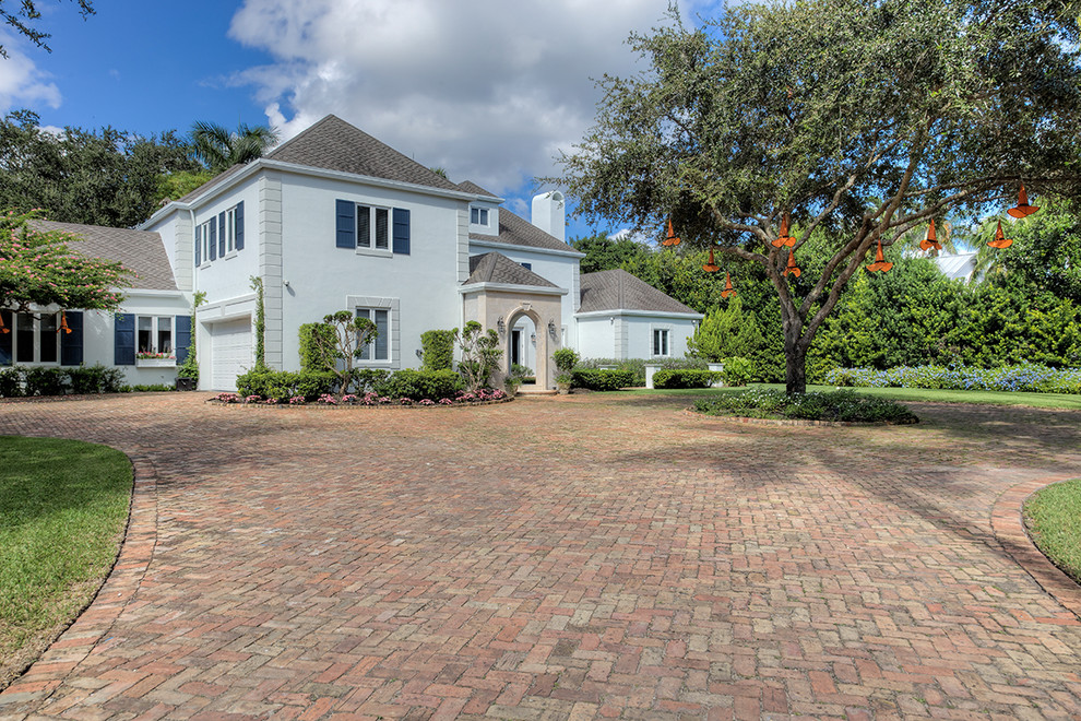 This is an example of a world-inspired front driveway garden for autumn in Miami with brick paving.