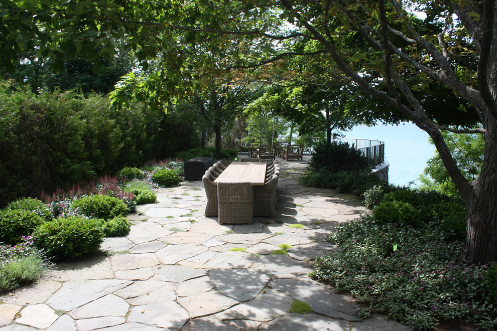 Imagen de jardín tradicional en patio trasero con adoquines de piedra natural
