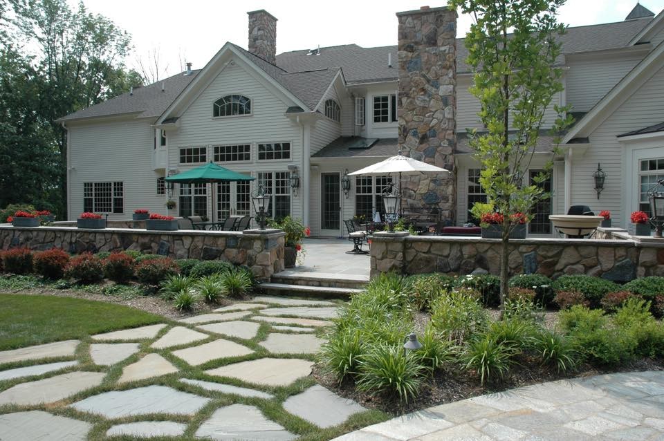 Photo of a large traditional full sun backyard stone landscaping in Other for summer.
