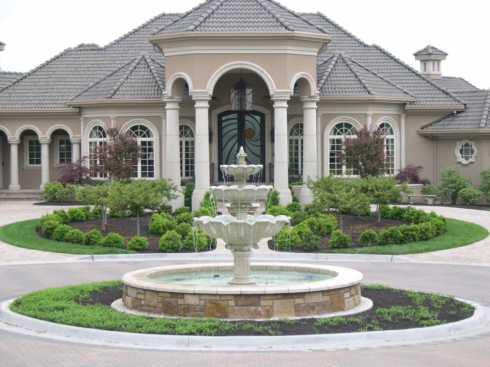 Design ideas for an expansive traditional front driveway full sun garden in Kansas City with a water feature and brick paving.