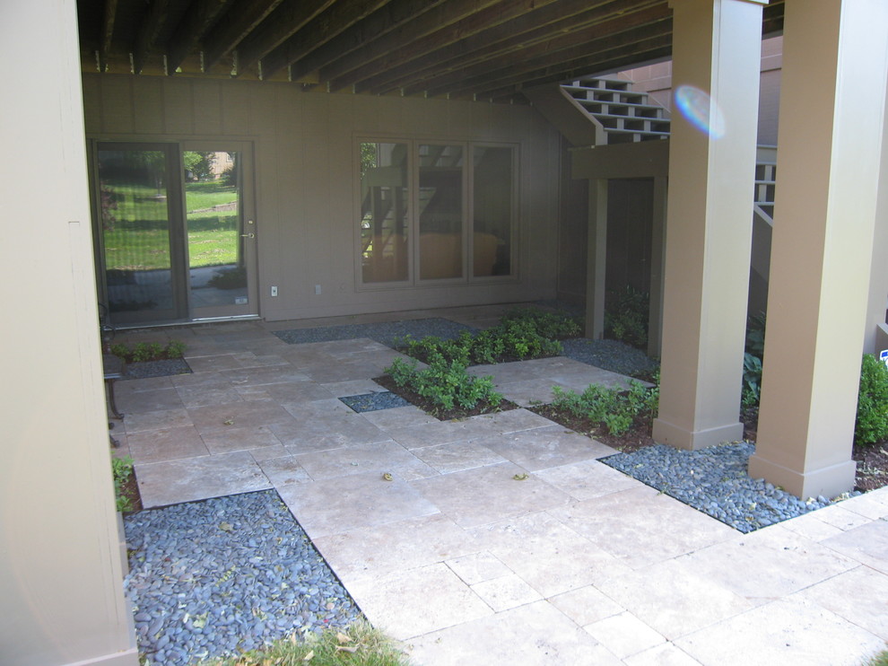 Cette image montre un petit jardin à la française arrière minimaliste l'été avec une exposition ombragée et des pavés en pierre naturelle.