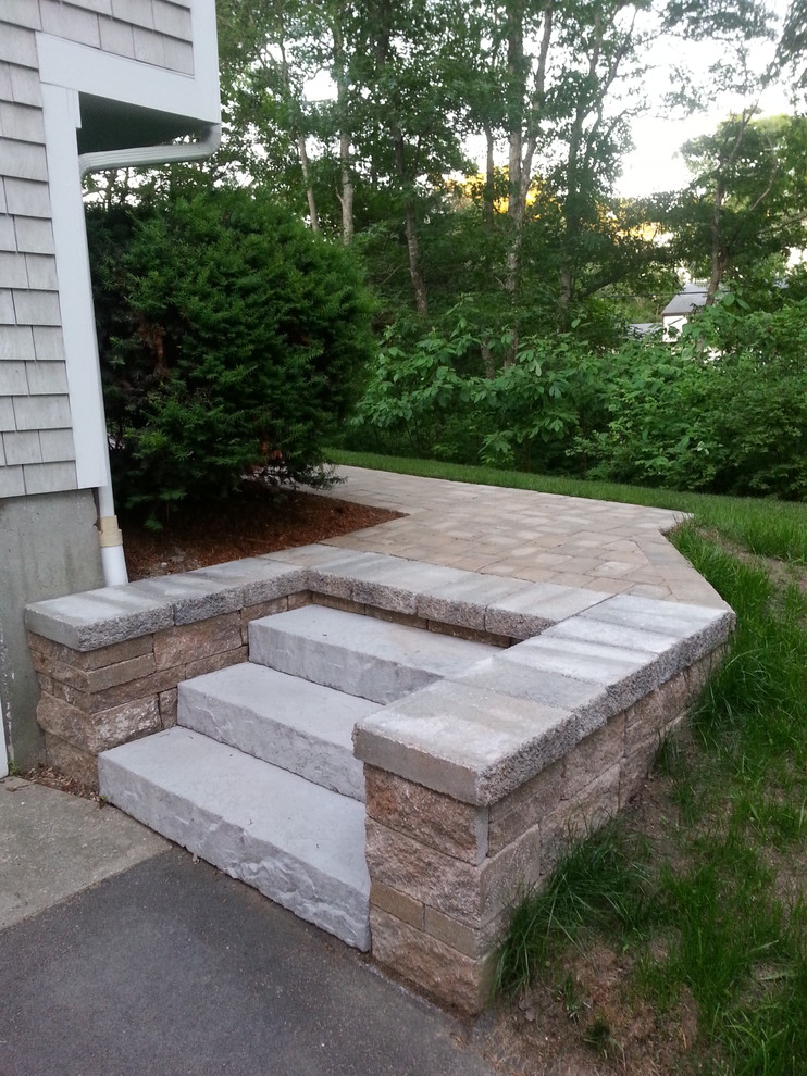 Photo of a mid-sized traditional partial sun front yard stone driveway in Boston.