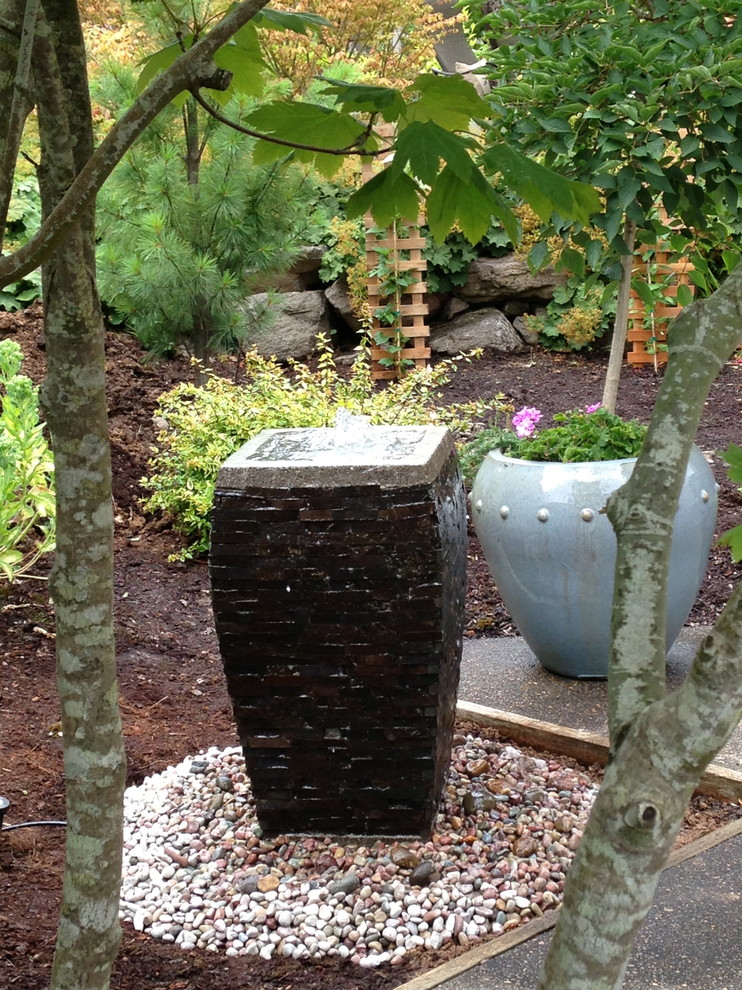 Photo of a small traditional partial sun backyard water fountain landscape in Portland.