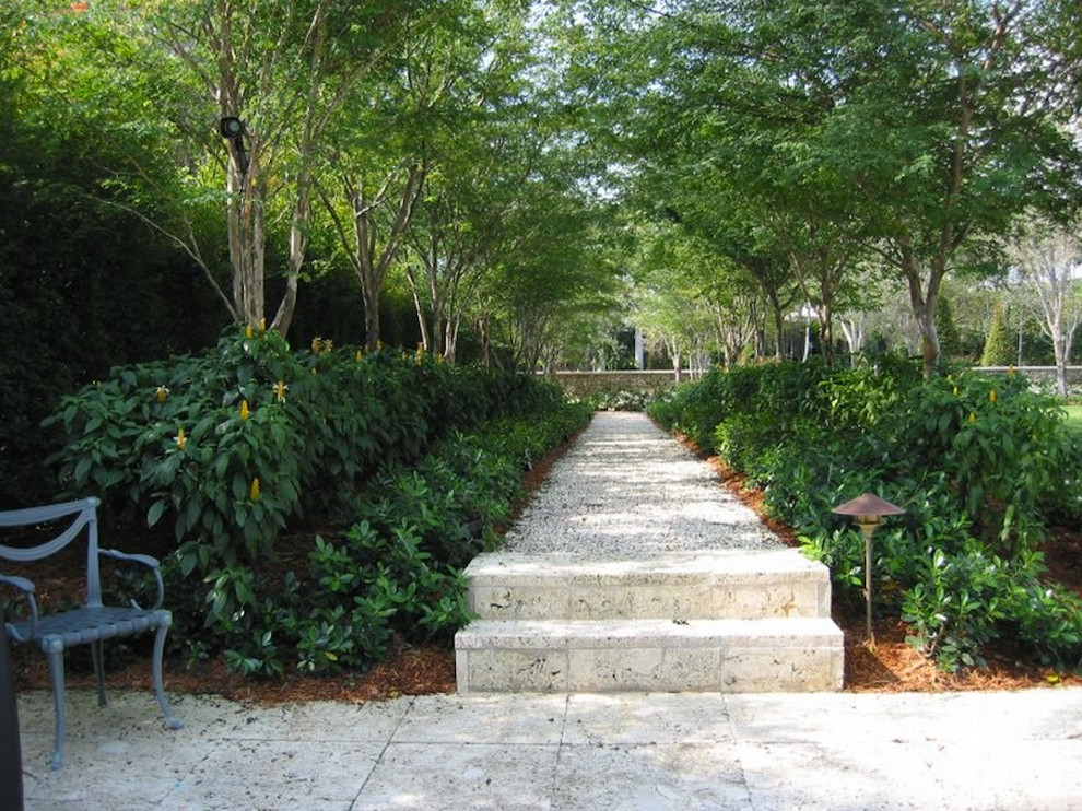 Foto di un grande giardino tropicale esposto a mezz'ombra in cortile con un ingresso o sentiero e pavimentazioni in pietra naturale