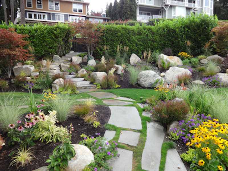 This is an example of a medium sized traditional back formal full sun garden for spring in Seattle with a garden path and natural stone paving.
