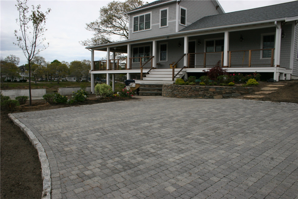 Design ideas for a large traditional front yard concrete paver retaining wall landscape in Boston.