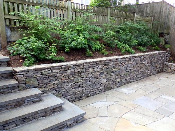 Photo of a large contemporary back garden in Boston with a retaining wall.