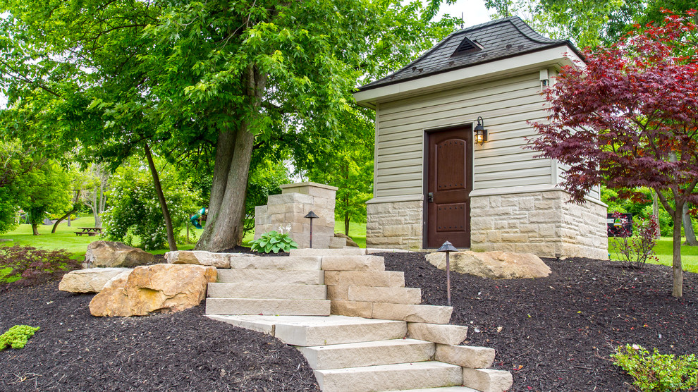 This is an example of a backyard stone retaining wall landscape in Other.