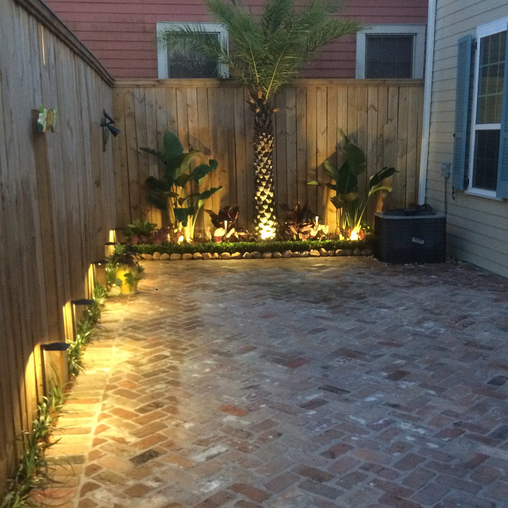 This is an example of a small craftsman full sun courtyard brick landscaping in New Orleans.