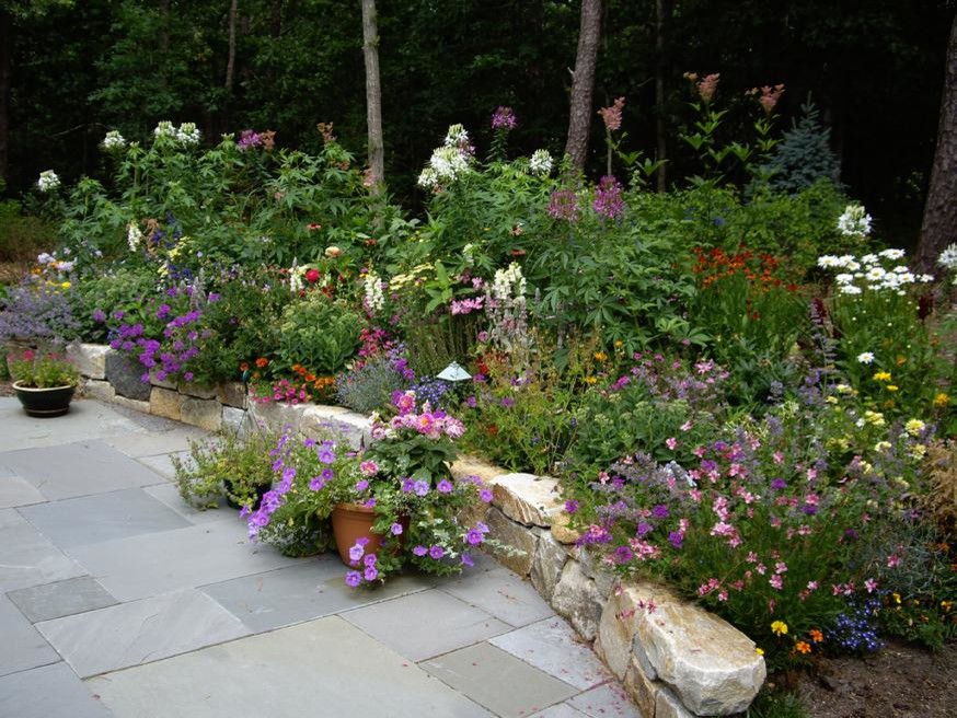Idées déco pour un jardin arrière classique de taille moyenne avec un mur de soutènement, une exposition partiellement ombragée et des pavés en pierre naturelle.