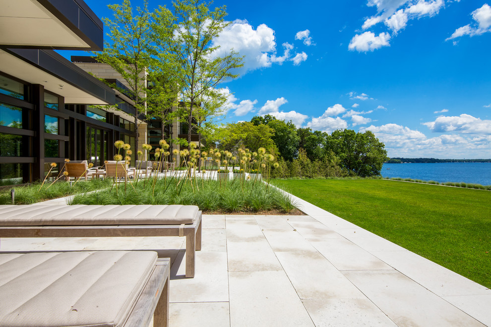Esempio di un ampio giardino formale contemporaneo esposto in pieno sole dietro casa in estate con un ingresso o sentiero e pavimentazioni in cemento