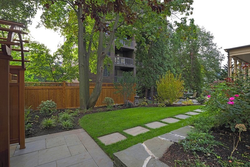 Пример оригинального дизайна: большой солнечный участок и сад на заднем дворе в современном стиле с садовой дорожкой или калиткой, хорошей освещенностью и покрытием из каменной брусчатки