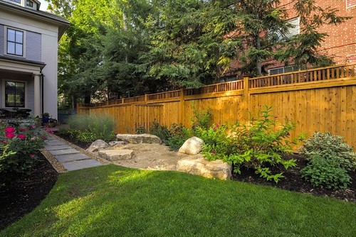 This thoughtfully designed outdoor space (below) features a shaded grassy area with a natural sandbox and a dog-safe edible garden—perfect for both kids and pets.