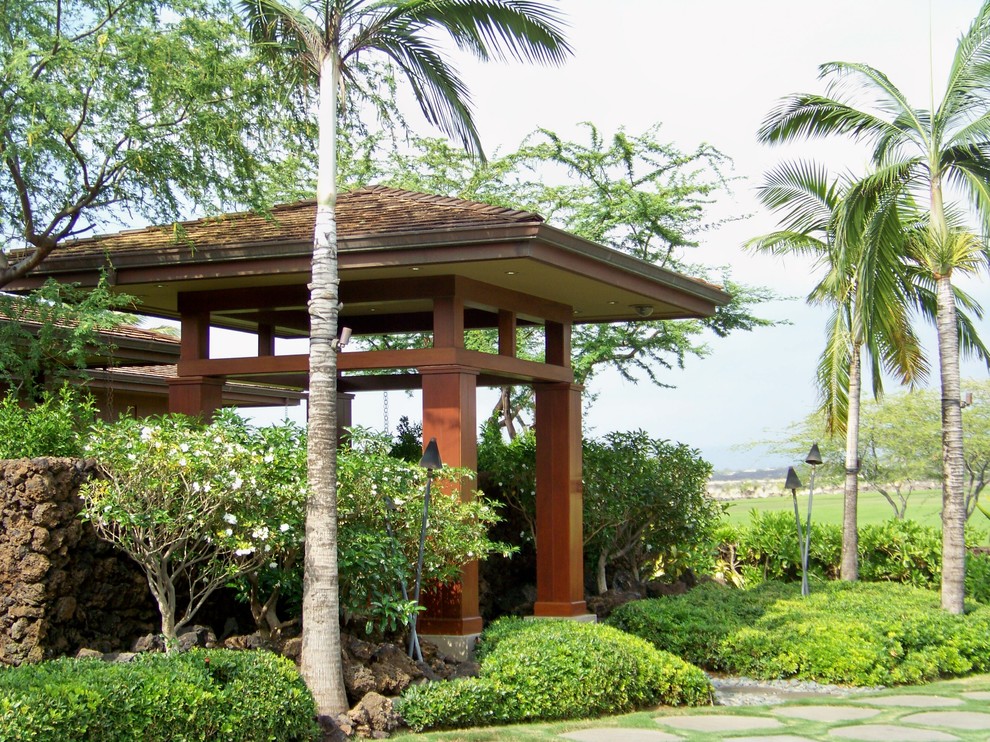 Imagen de jardín tropical de tamaño medio en patio delantero con exposición parcial al sol y adoquines de piedra natural