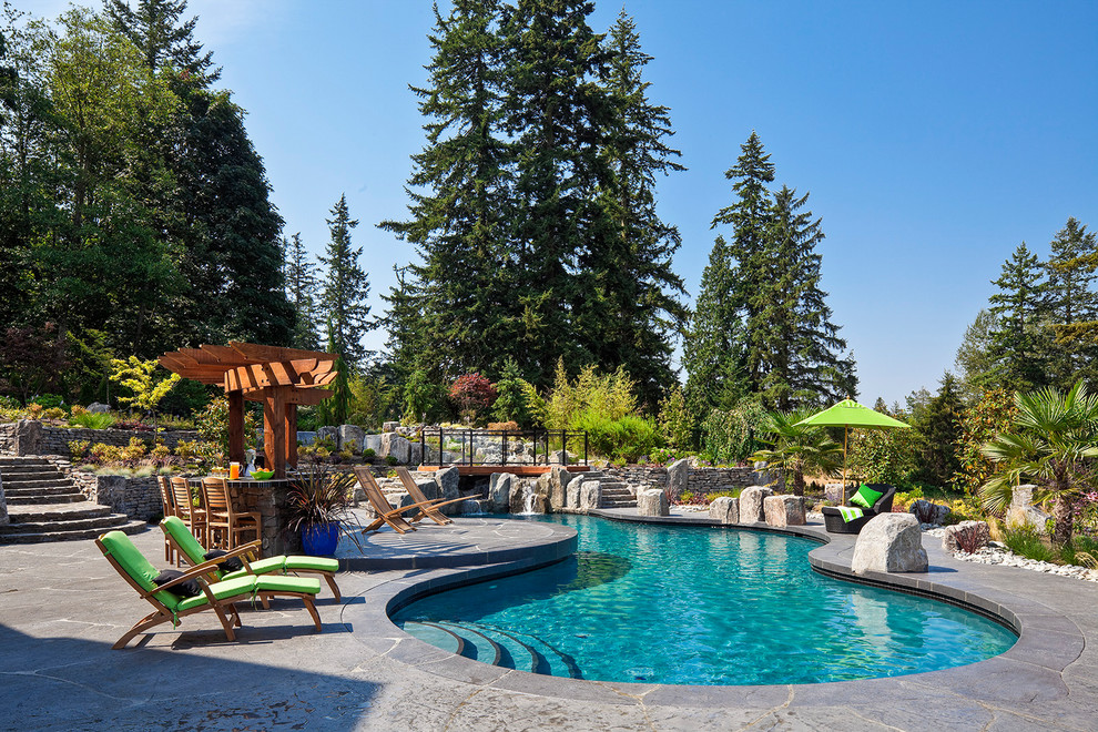 Foto di un ampio giardino formale minimalista esposto in pieno sole in estate con un pendio, una collina o una riva e pavimentazioni in pietra naturale