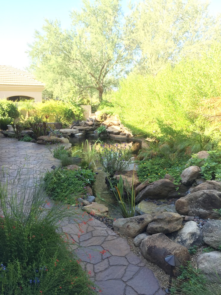Design ideas for a large mediterranean back partial sun garden in Phoenix with a pond.