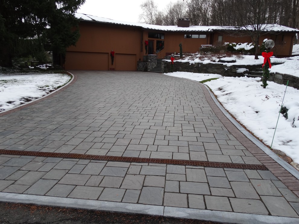Foto di un vialetto d'ingresso tradizionale davanti casa in inverno con un ingresso o sentiero e pavimentazioni in cemento