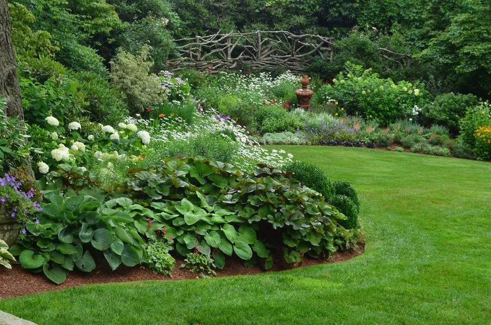 Inspiration for a large traditional full sun backyard mulch landscaping in Other.