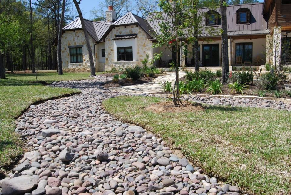 Inspiration for an expansive farmhouse partial sun garden in Houston with natural stone paving.