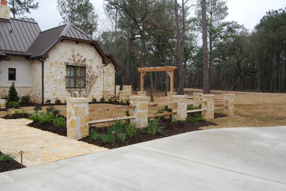 Expansive rural partial sun garden in Houston with natural stone paving.