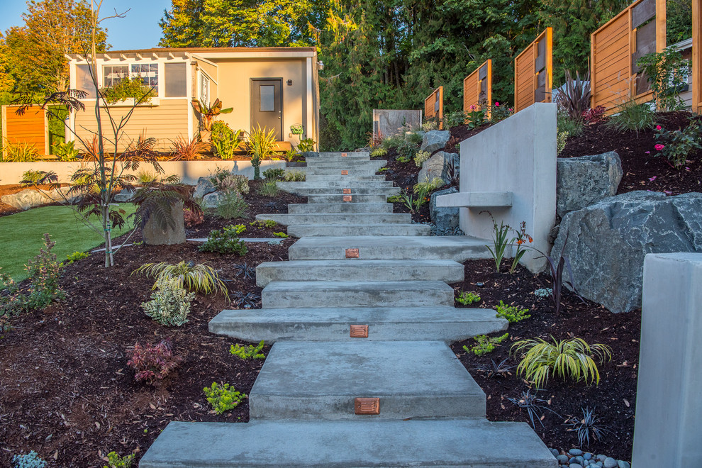 Свежая идея для дизайна: участок и сад среднего размера на переднем дворе в стиле модернизм с подпорной стенкой и мощением тротуарной плиткой - отличное фото интерьера