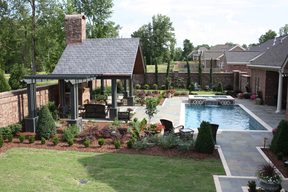 This is an example of a classic back full sun garden in Jackson with a fire feature and brick paving.