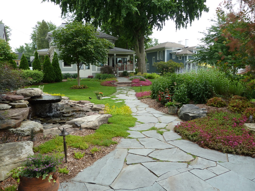 Traditional partial sun garden in Grand Rapids with a garden path and natural stone paving.