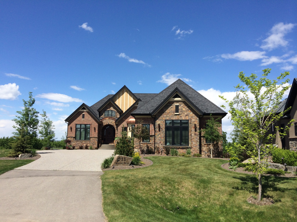 This is an example of a large rustic front formal garden in Calgary with a flowerbed and gravel.