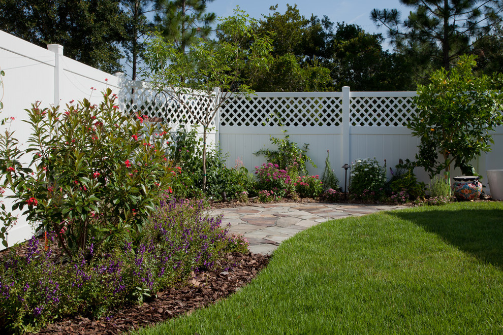 This is an example of a contemporary backyard stone landscaping in Orlando.