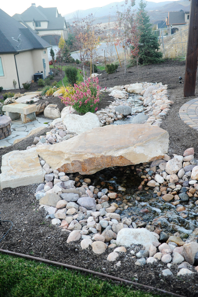 Inspiration for a large rustic full sun hillside brick water fountain landscape in Salt Lake City for fall.