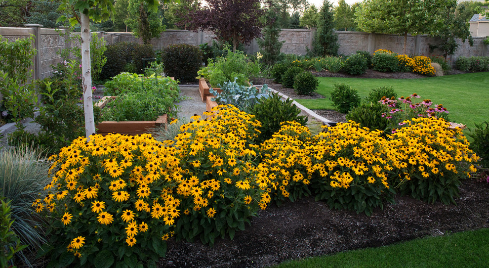 Cette image montre un grand jardin à la française latéral traditionnel avec une exposition ensoleillée et du gravier.