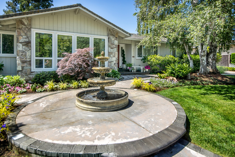 This is an example of a mid-sized traditional full sun front yard concrete paver water fountain landscape in San Francisco for summer.