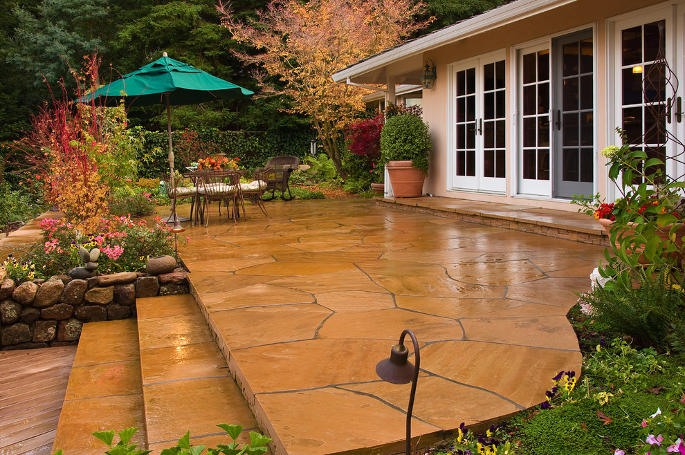 Foto di un giardino classico dietro casa con pavimentazioni in pietra naturale