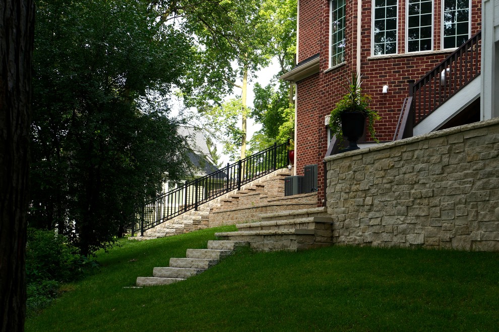 Пример оригинального дизайна: участок и сад на заднем дворе в классическом стиле с подпорной стенкой